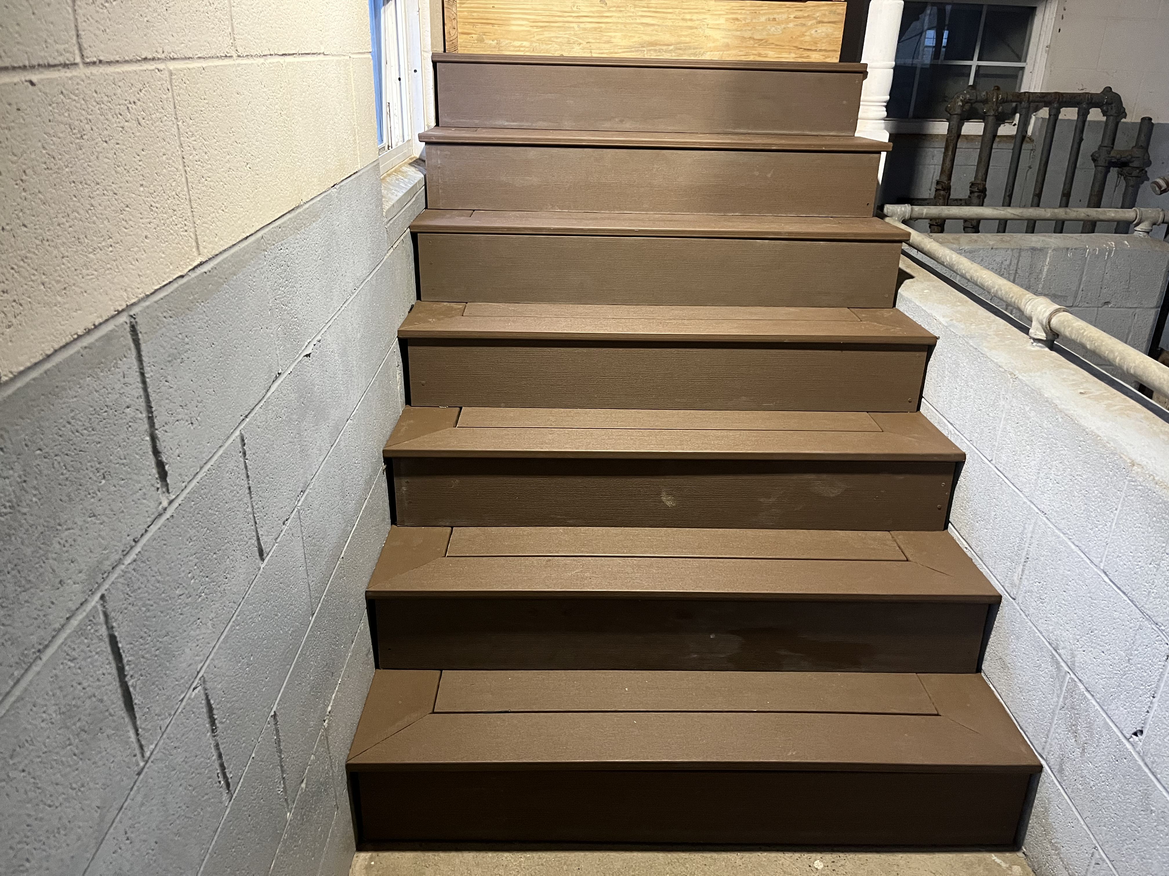 Completed interior staircase with brown composite treads and risers