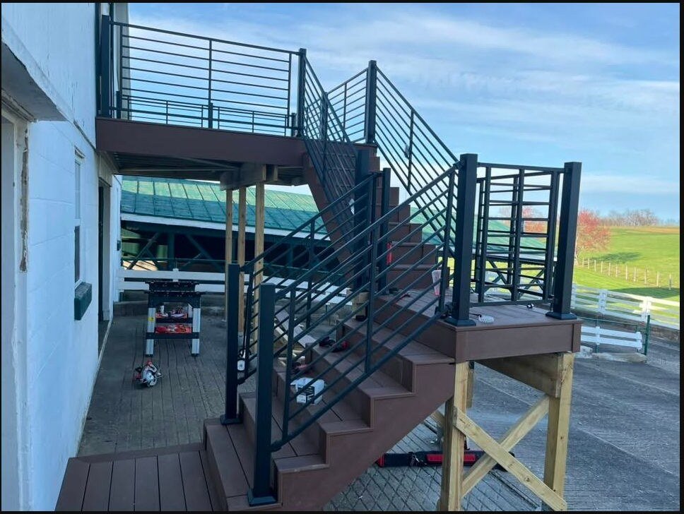 Elevated composite deck and stairs with custom black metal railing
