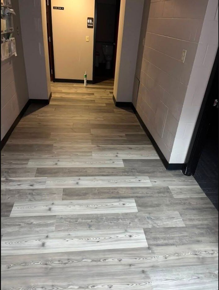 Finished plank flooring installed through a residential hallway