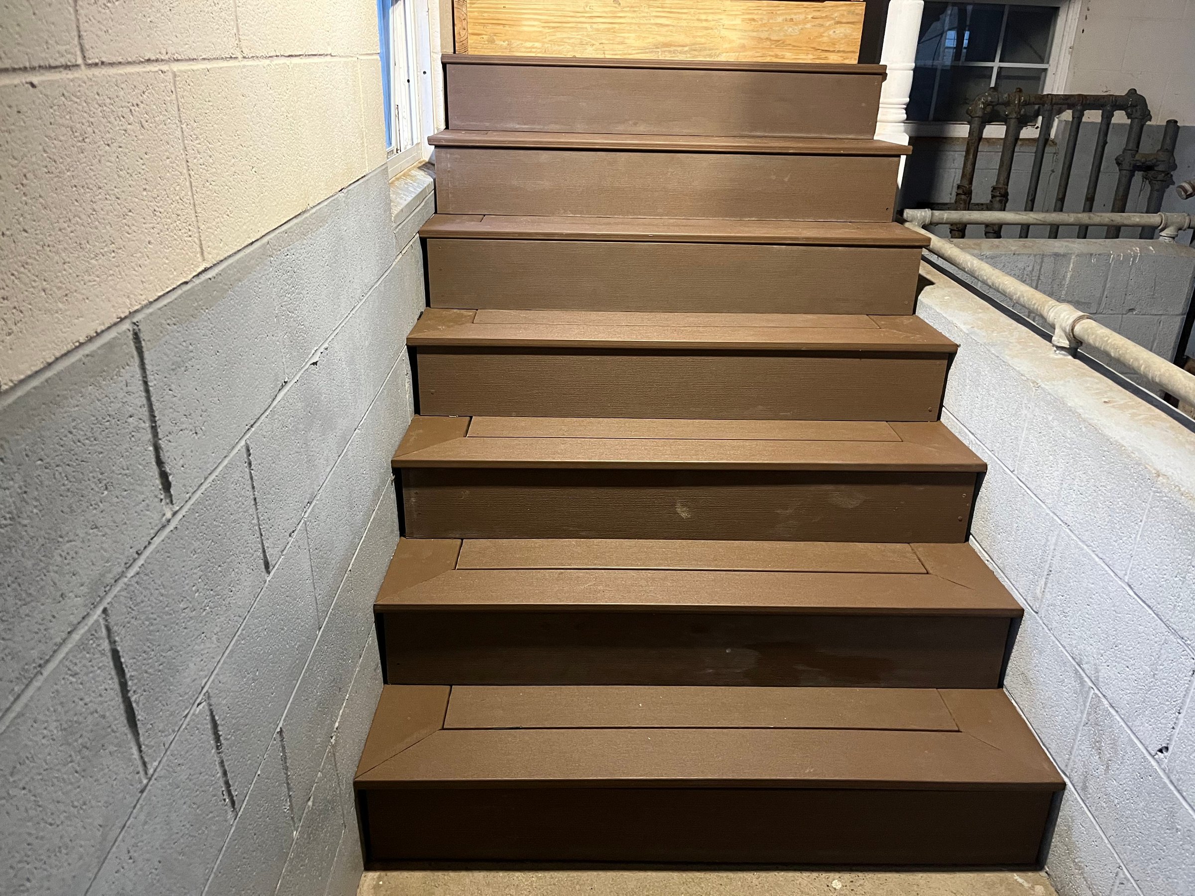 Completed interior staircase with brown composite treads and risers