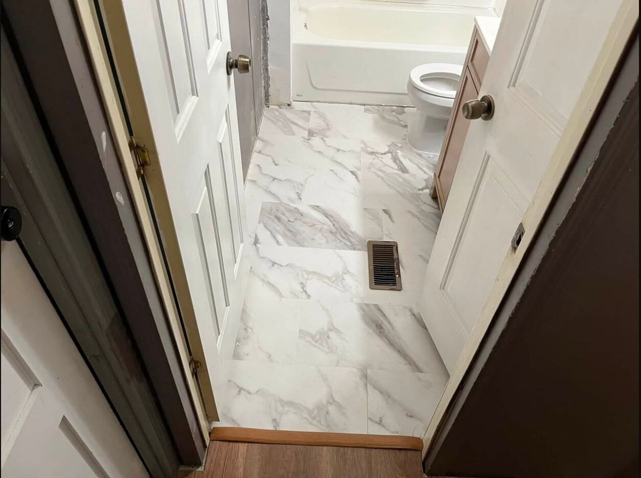 Completed marble-look bathroom flooring viewed from the doorway