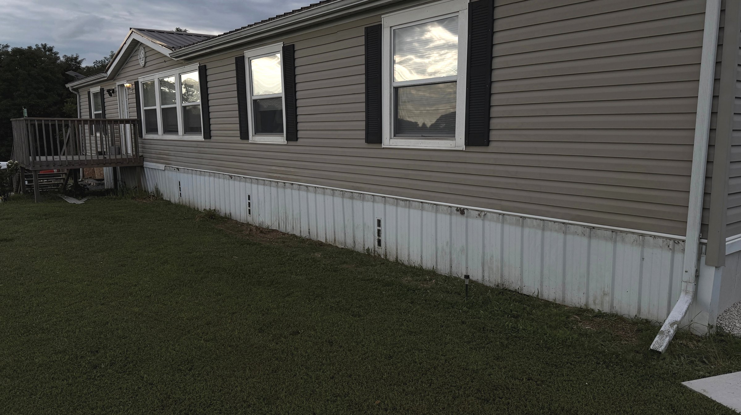 Existing corrugated skirting along the side of the home before the DuraSkirt installation
