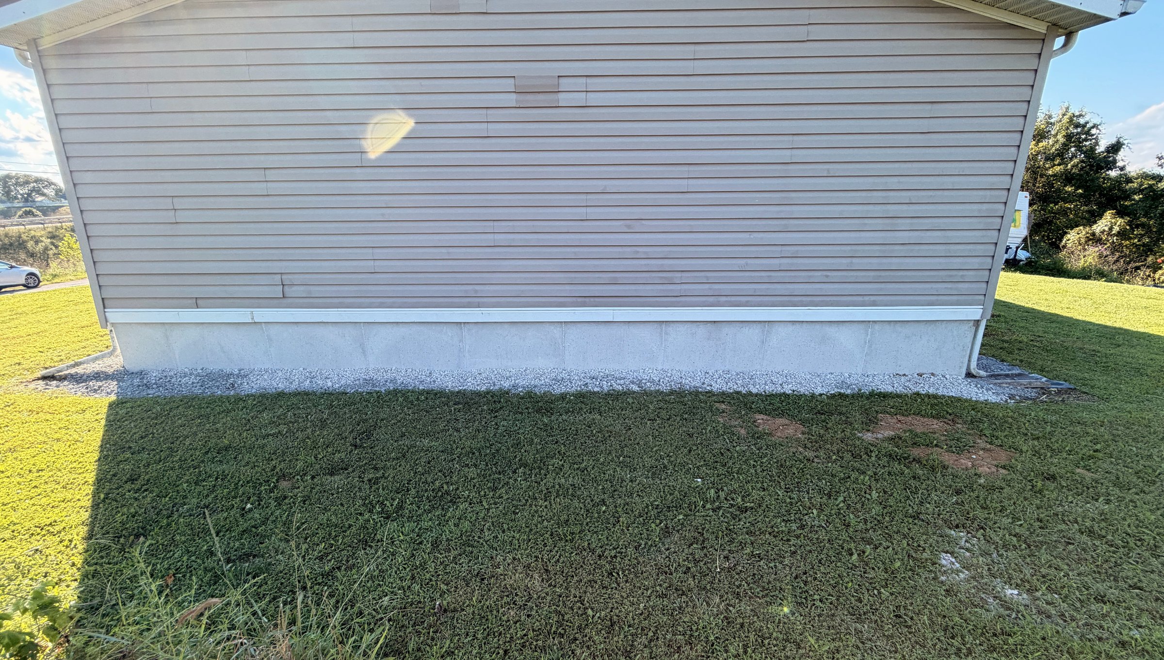Finished DuraSkirt concrete-panel skirting across the gable end of the home